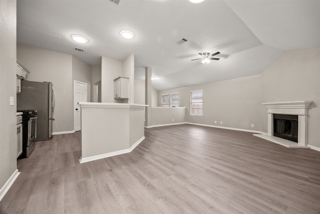 unfurnished living room with light hardwood / wood-style floors, vaulted ceiling, and ceiling fan