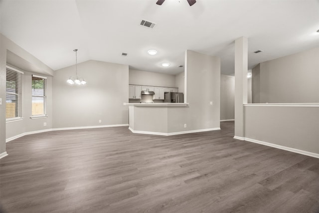 unfurnished living room featuring ceiling fan with notable chandelier, dark hardwood / wood-style flooring, and lofted ceiling