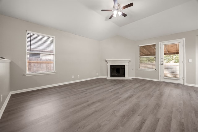 unfurnished living room with a wealth of natural light, wood-type flooring, and vaulted ceiling