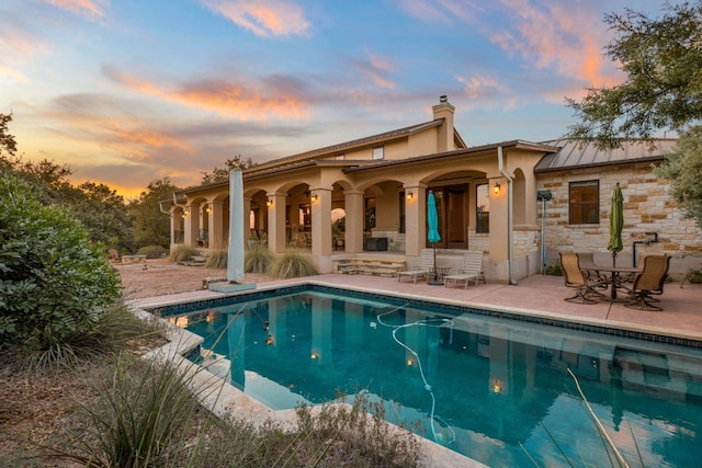 back house at dusk with a patio area