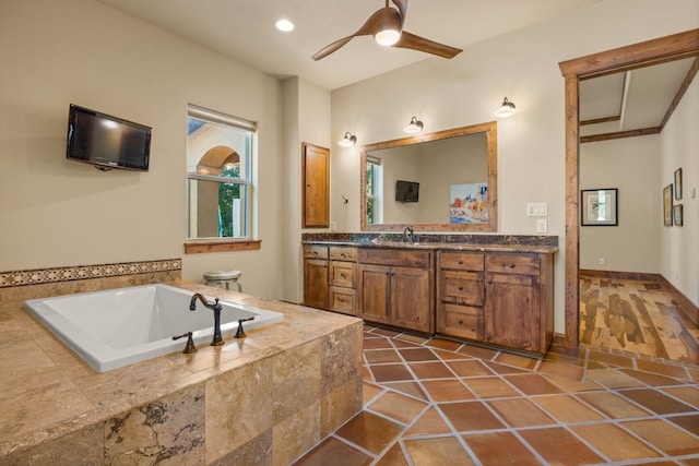 bathroom featuring ceiling fan, tile patterned floors, tiled bath, toilet, and vanity