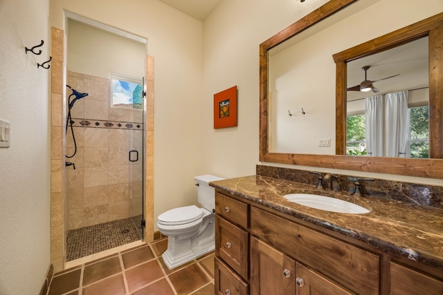 bathroom featuring vanity, tile patterned floors, ceiling fan, toilet, and a shower with shower door