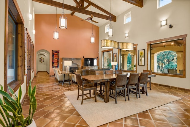 tiled dining room featuring beamed ceiling, high vaulted ceiling, and ceiling fan