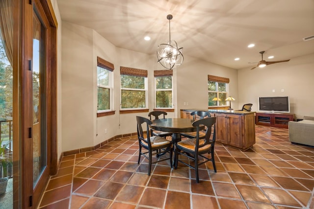 tiled dining area with plenty of natural light and ceiling fan with notable chandelier