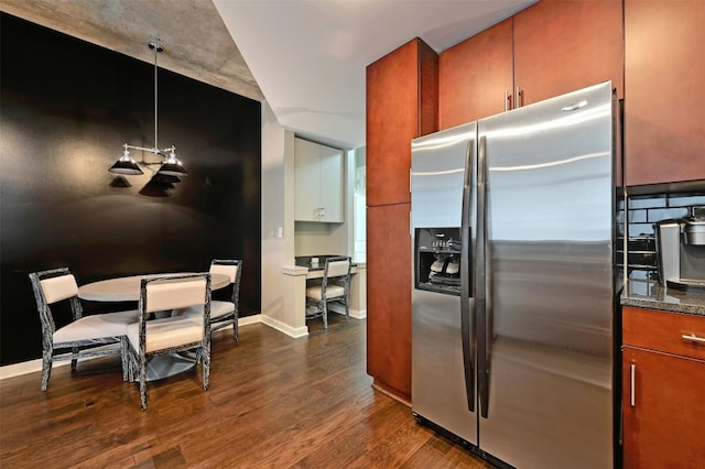 kitchen featuring stainless steel fridge, pendant lighting, and dark wood-type flooring