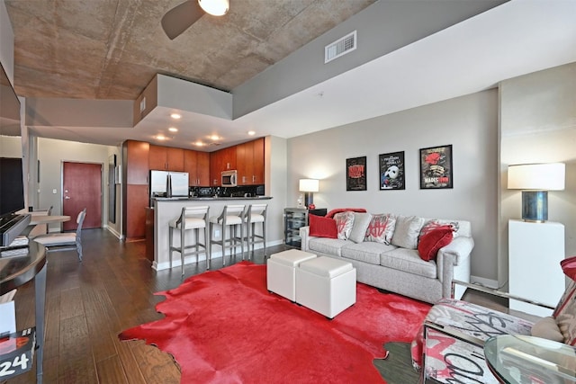 living room with ceiling fan and dark hardwood / wood-style flooring