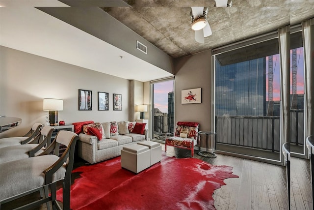 living room featuring wood-type flooring and ceiling fan