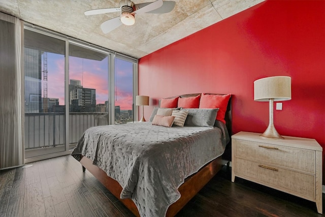 bedroom with access to outside, ceiling fan, dark hardwood / wood-style floors, and a wall of windows