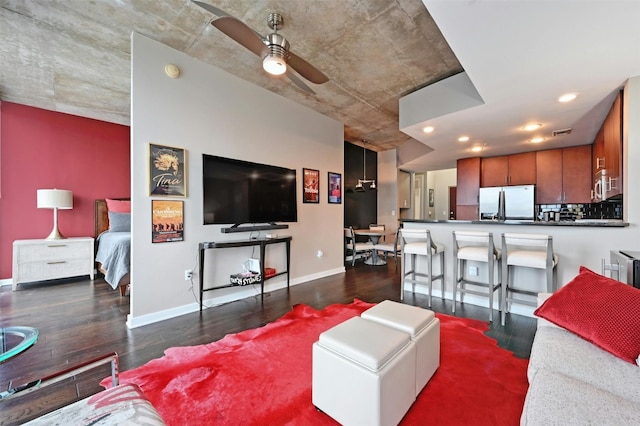 living room featuring ceiling fan and dark hardwood / wood-style flooring