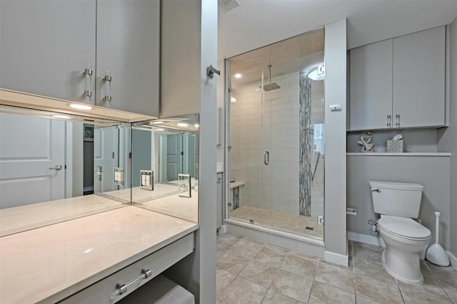 bathroom with tile patterned floors, a shower with door, vanity, and toilet