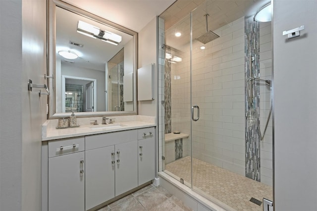 bathroom with tile patterned floors, a shower with door, and vanity