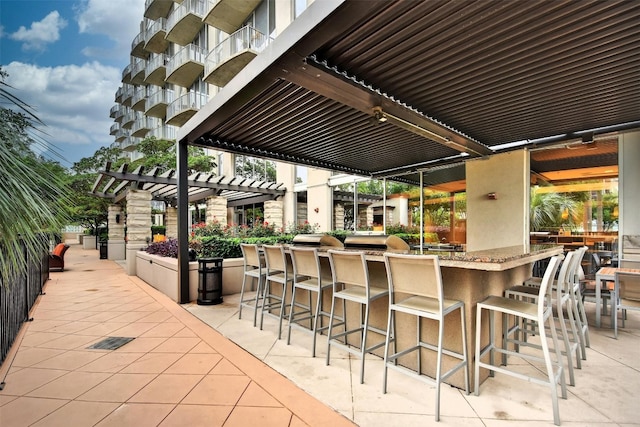 view of patio with a pergola, grilling area, and an outdoor bar