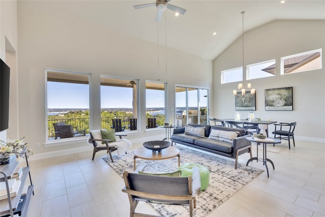 living room featuring a wealth of natural light, high vaulted ceiling, and ceiling fan with notable chandelier