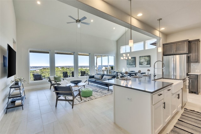 kitchen featuring white cabinets, decorative light fixtures, high vaulted ceiling, and a wealth of natural light