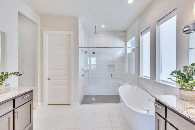 bathroom with plus walk in shower, vanity, and tile patterned floors