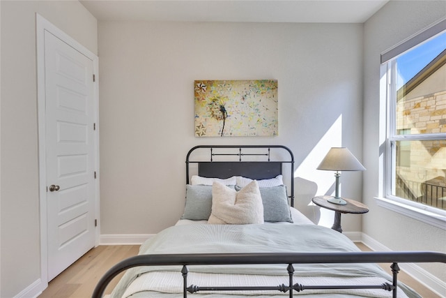 bedroom with light wood-type flooring and multiple windows