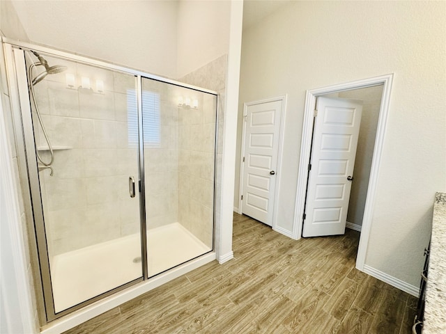 bathroom featuring wood-type flooring and an enclosed shower