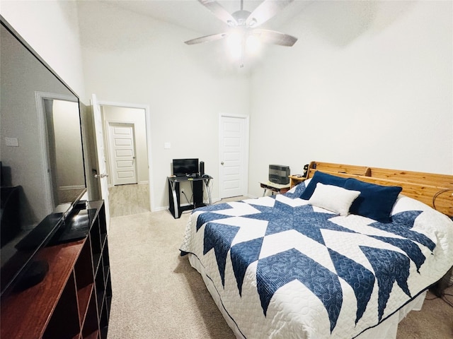 bedroom featuring ceiling fan, a towering ceiling, and light colored carpet