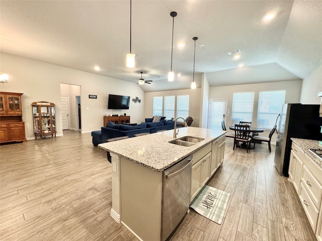 kitchen with plenty of natural light, an island with sink, lofted ceiling, and appliances with stainless steel finishes