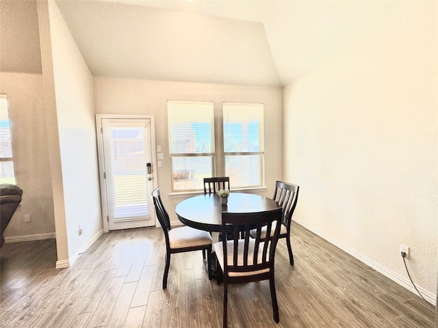 dining area with hardwood / wood-style floors and lofted ceiling