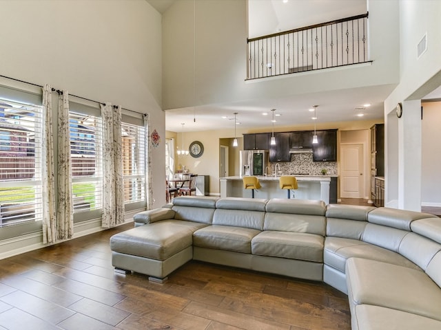 living room with sink, high vaulted ceiling, and dark hardwood / wood-style floors