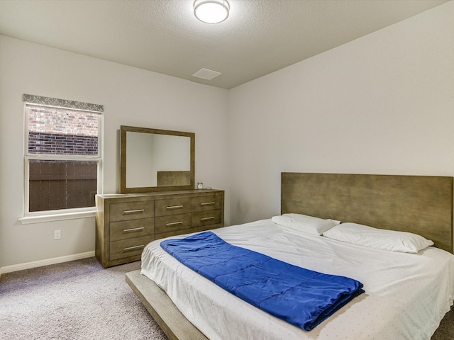 bedroom with a textured ceiling and light carpet