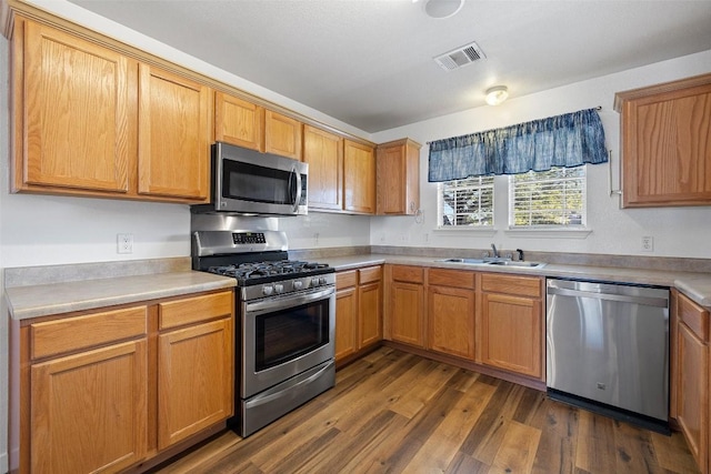 kitchen featuring stainless steel appliances, dark hardwood / wood-style floors, and sink