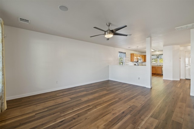 unfurnished living room with ceiling fan and dark hardwood / wood-style flooring