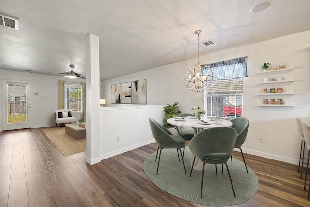 dining area featuring dark wood-type flooring and ceiling fan with notable chandelier