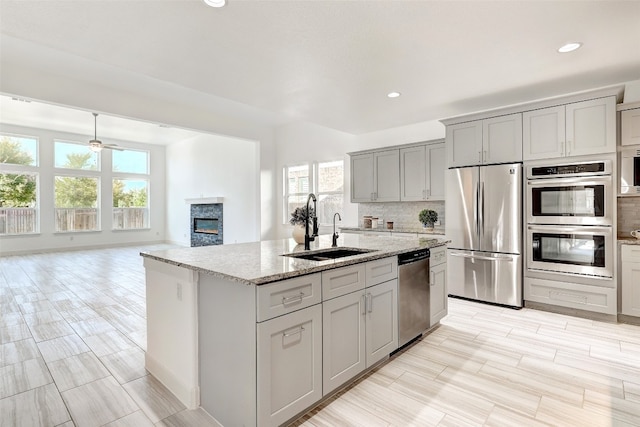 kitchen featuring tasteful backsplash, a healthy amount of sunlight, sink, and stainless steel appliances