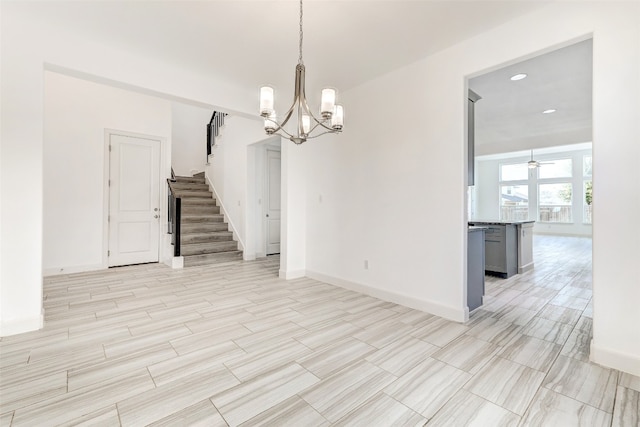 interior space with ceiling fan with notable chandelier