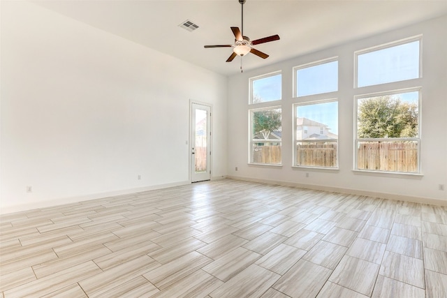 unfurnished room featuring a towering ceiling and ceiling fan