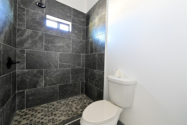 bathroom with tiled shower and toilet