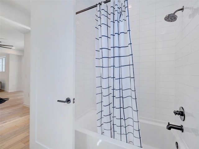 bathroom with shower / bathtub combination with curtain and wood-type flooring