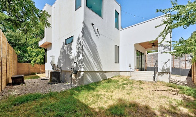 rear view of property featuring ceiling fan and cooling unit