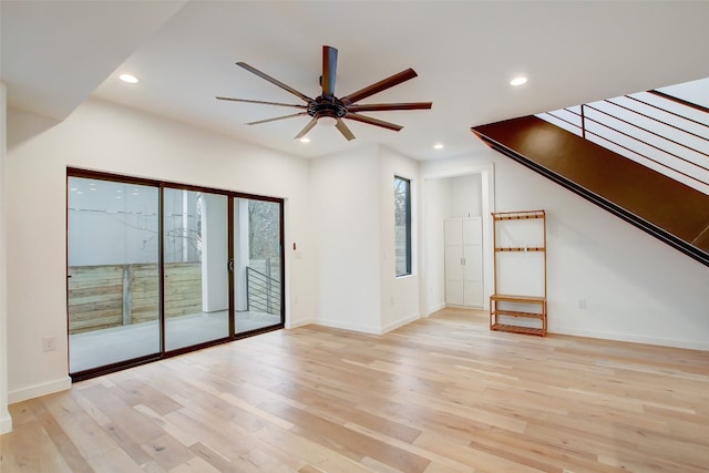 unfurnished living room with ceiling fan, light wood-type flooring, and a wealth of natural light