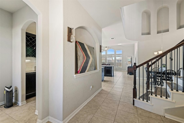 hallway featuring light tile patterned floors and an inviting chandelier