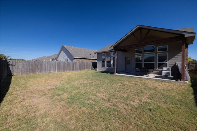 back of house with a yard and a patio