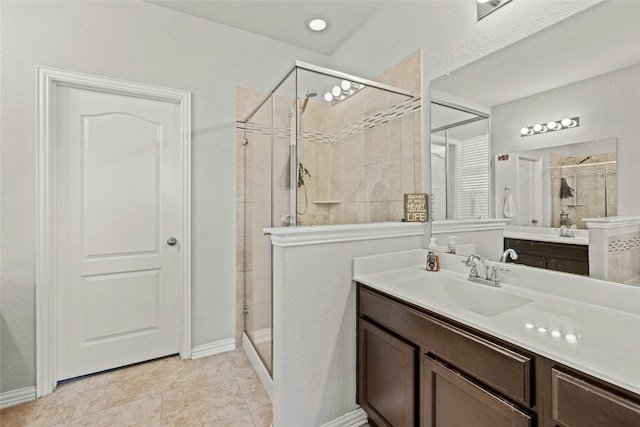 bathroom with tile patterned floors, a shower with door, and vanity