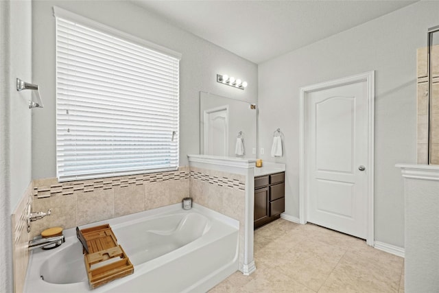 bathroom featuring tile patterned flooring, vanity, a wealth of natural light, and a bathing tub