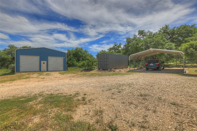 view of yard with a carport, a garage, and an outbuilding