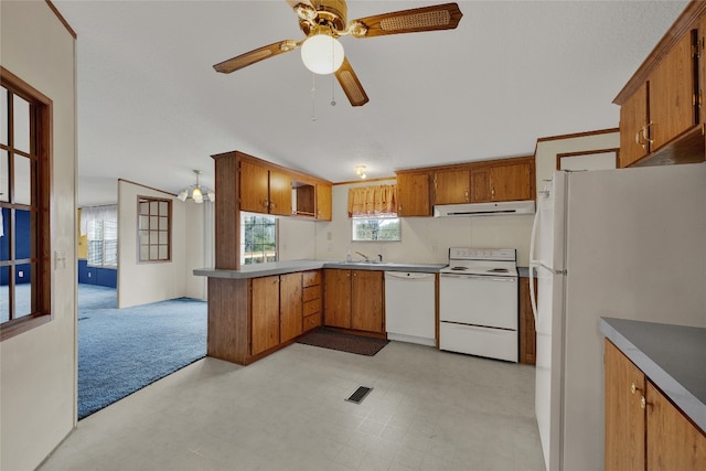 kitchen featuring white appliances, lofted ceiling, ceiling fan with notable chandelier, sink, and kitchen peninsula