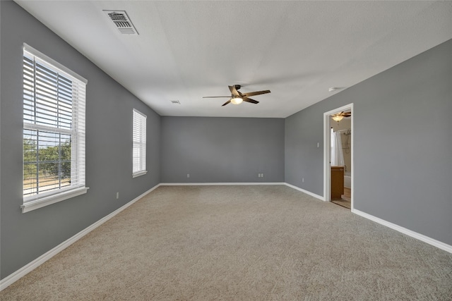 carpeted spare room featuring ceiling fan