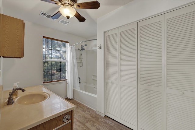 bathroom featuring hardwood / wood-style floors, vanity, shower / bathtub combination with curtain, and ceiling fan