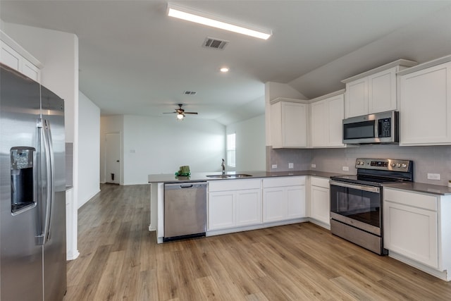 kitchen with kitchen peninsula, sink, light hardwood / wood-style flooring, and appliances with stainless steel finishes