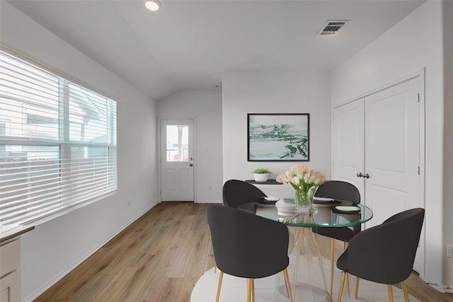 dining area featuring light hardwood / wood-style floors and lofted ceiling