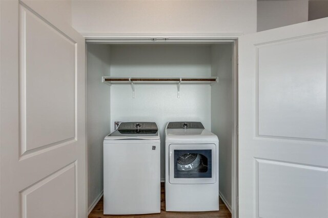 clothes washing area featuring washer and dryer and hardwood / wood-style floors