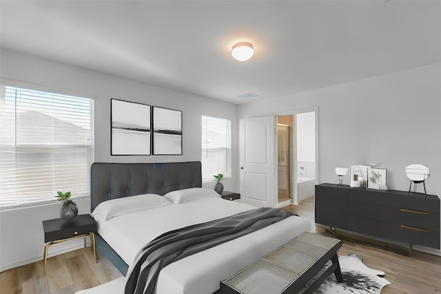 bedroom featuring ensuite bath, light hardwood / wood-style flooring, and multiple windows