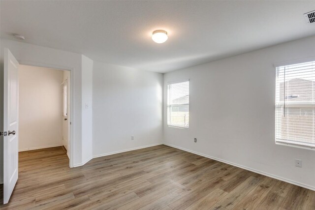 empty room featuring light wood-type flooring and plenty of natural light