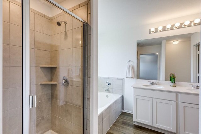 bathroom featuring wood-type flooring, vanity, and independent shower and bath